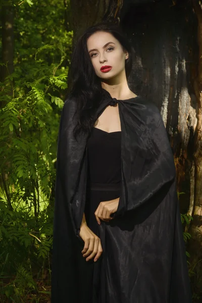 Bella donna bruna in abito nero e mantello nero — Foto Stock