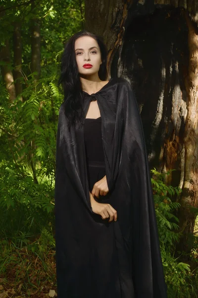 Vacker brunett kvinna i svart klänning och svart kappa — Stockfoto