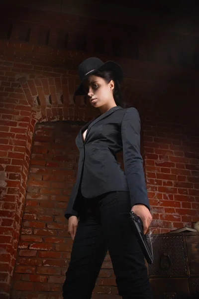 Noir film style woman in a black suit with gun — Stock Photo, Image