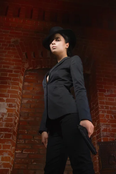 Frau im Noir-Film-Stil im schwarzen Anzug mit Waffe — Stockfoto