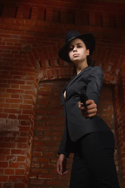 Noir mujer estilo cine en un traje negro con pistola — Foto de Stock