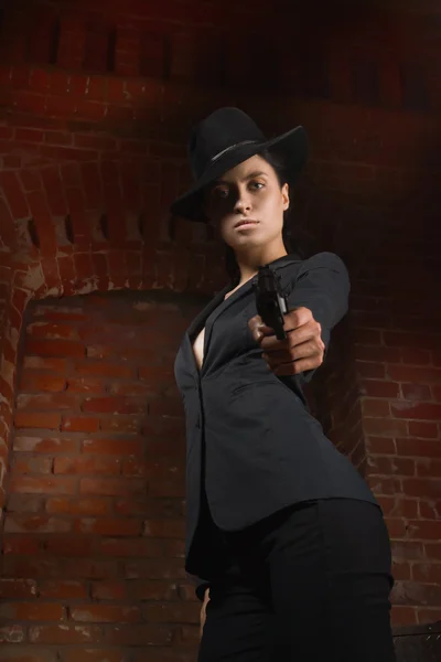 Женщина в черном костюме в стиле нуар с пистолетом — стоковое фото