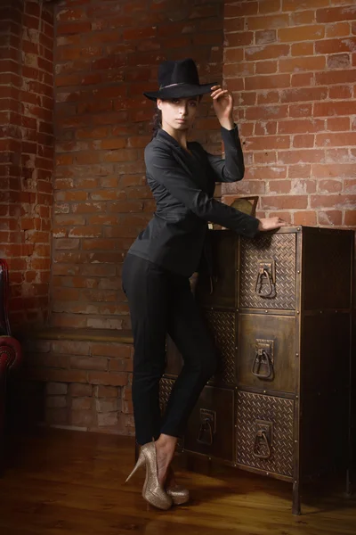 Eleganta fashionabla kvinnan klädd i svart kostym och hatt — Stockfoto