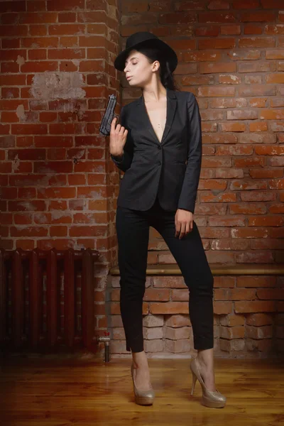 Noir film style woman in a black suit with gun — Stock Photo, Image