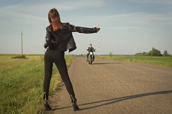 Girl votes hitchhiking on a road — Stock Photo, Image