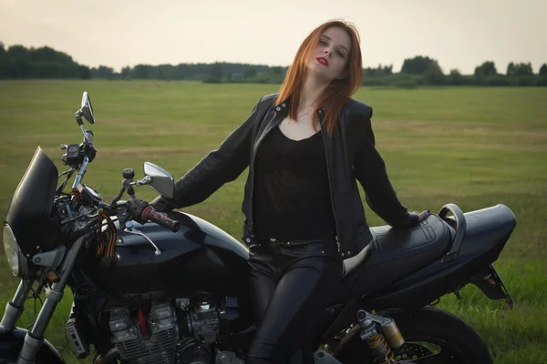 Menina motociclista em uma jaqueta de couro em uma motocicleta — Fotografia de Stock