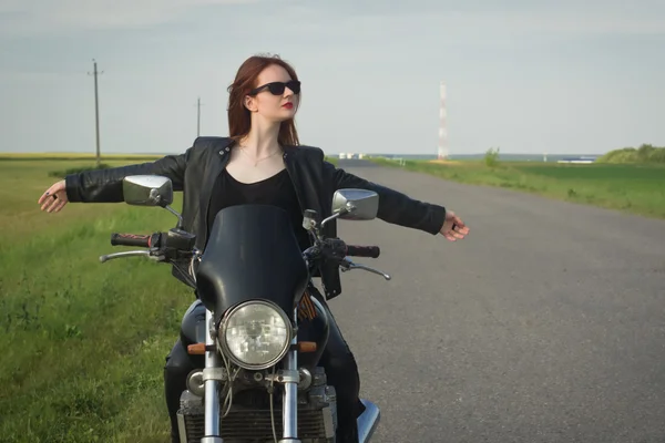 Biker flicka i en läder jacka på en motorcykel — Stockfoto