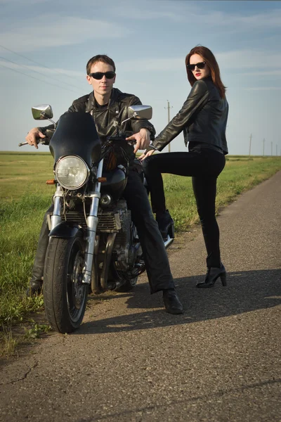 Motoqueiro homem e menina fica na estrada — Fotografia de Stock