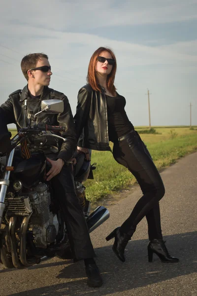 Motoqueiro homem e menina fica na estrada — Fotografia de Stock