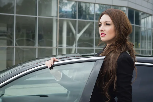 Mujer de negocios de pie en la calle coche de fondo —  Fotos de Stock