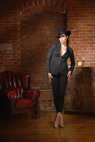 Siyah takım elbise ve şapka giymiş şık moda kadın — Stok fotoğraf