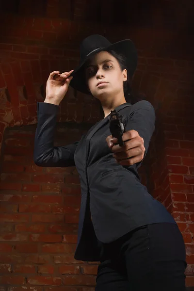 Noir film style woman in a black suit with gun — Stock Photo, Image