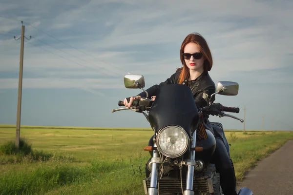 Menina motociclista em uma jaqueta de couro em uma motocicleta — Fotografia de Stock