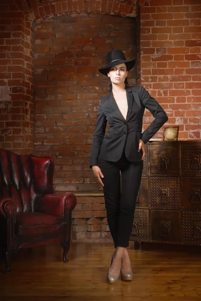 Siyah takım elbise ve şapka giymiş şık moda kadın — Stok fotoğraf