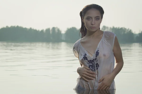 Sexy vrouw in wit overhemd poseren op het bos meer — Stockfoto