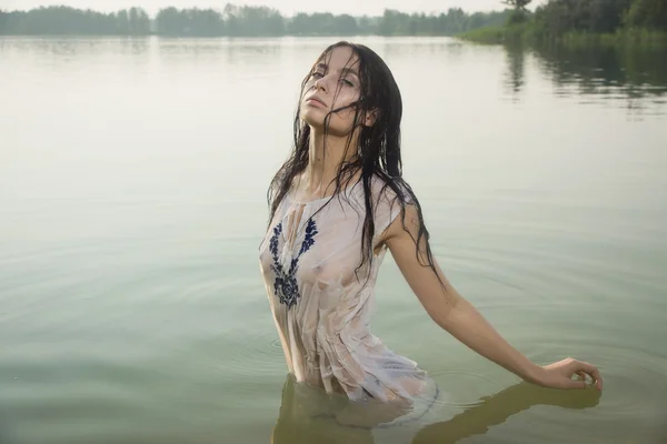 Сексуальная женщина в белой рубашке позирует на лесном озере — стоковое фото
