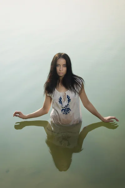 Сексуальная женщина в белой рубашке позирует на лесном озере — стоковое фото
