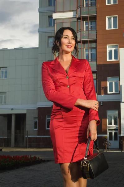 Attraktive Geschäftsfrau im roten Anzug auf einer Straße — Stockfoto