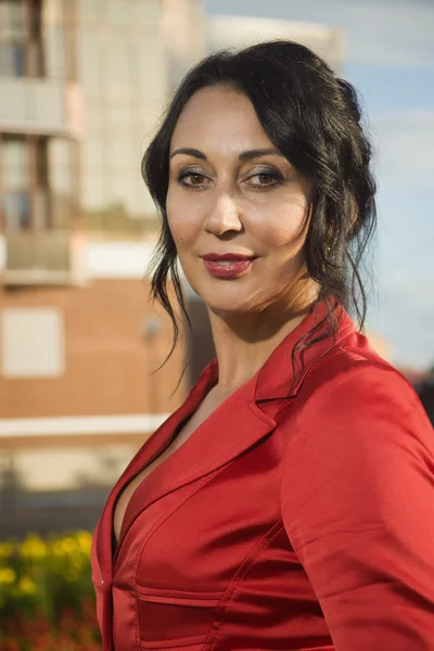 Attractive business woman in red suit on a street — Stock Photo, Image