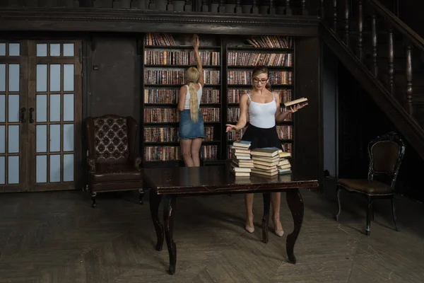 两个年轻的图书馆员在古典图书馆房间里 — 图库照片