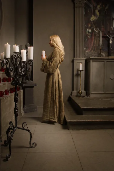 Черниця молиться в середньовічній церкві — стокове фото