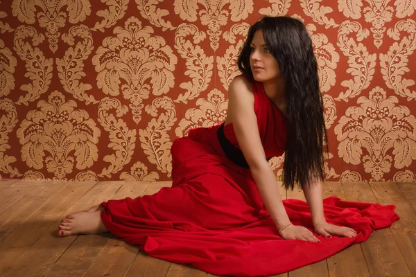 Morena de moda en un vestido largo rojo — Foto de Stock