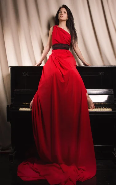 Morena na moda em um vestido vermelho longo — Fotografia de Stock