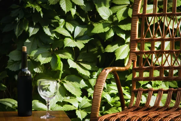 Silla de mimbre y botella de vino — Foto de Stock