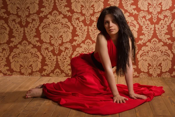 Μοντέρνα μελαχρινή σε ένα μακρύ κοκκινωπό φόρεμα — Φωτογραφία Αρχείου