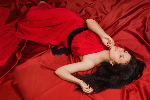 Fashionable brunette in a long red dress — Stock Photo, Image