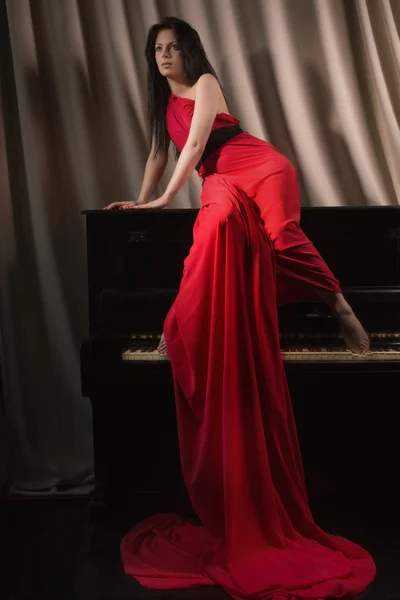 Bruna alla moda in un lungo vestito rosso — Foto Stock