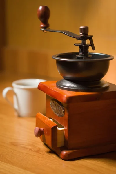 Macinino di caffè vecchio e tazza su un tavolo — Foto Stock