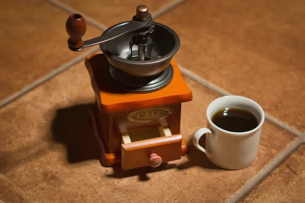 Macinino di caffè vecchio e tazza su un tavolo — Foto Stock