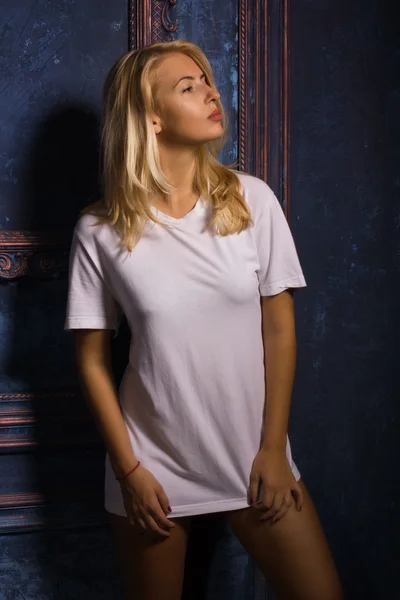 Горячая женщина в белой футболке позирует в готическом интерьере — стоковое фото
