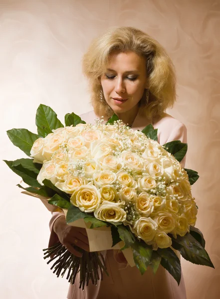 Mulher elegante com um grande buquê de rosas — Fotografia de Stock