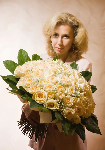 Mulher elegante com um grande buquê de rosas — Fotografia de Stock