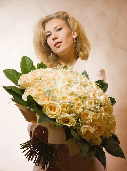 Mulher elegante com um grande buquê de rosas — Fotografia de Stock