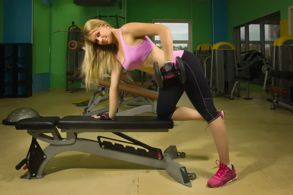 Chica en forma haciendo ejercicios con pesas en el gimnasio —  Fotos de Stock