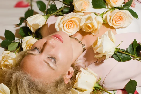 Piękna kobieta z róż, leżąc na łóżku — Zdjęcie stockowe