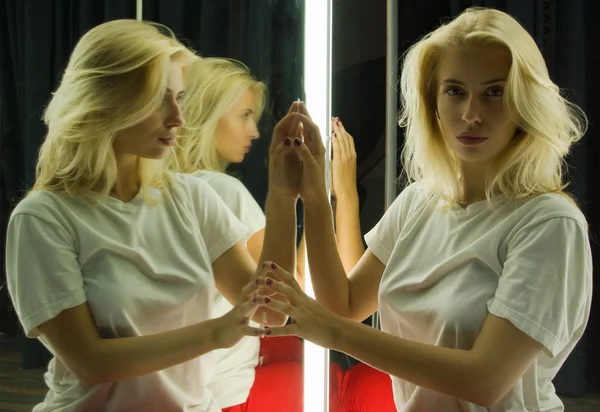 Sexy girl in white t-shirt and her reflection in mirror table — Stock Photo, Image