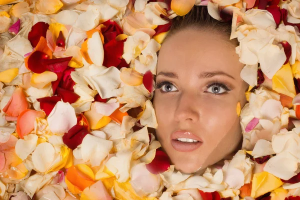 Beautiful sexy woman in bath with flowers petals