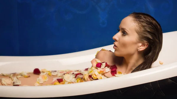 Mulher sexy bonita no banho com pétalas de flores — Fotografia de Stock
