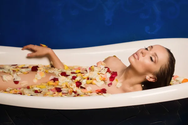 Çiçek yaprakları ile banyo güzel seksi kadın — Stok fotoğraf