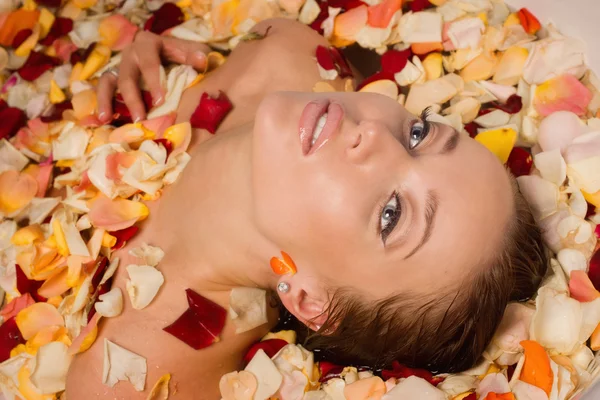 Hermosa mujer sexy en baño con pétalos de flores — Foto de Stock