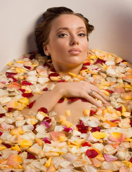 Mulher sexy bonita no banho com pétalas de flores — Fotografia de Stock