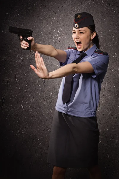 Woman police officer shooting with a pistol — Stock Photo, Image