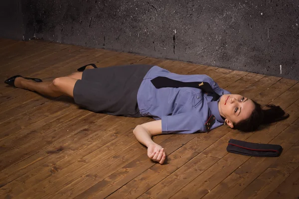 Женщина-полицейский лежит на полу — стоковое фото