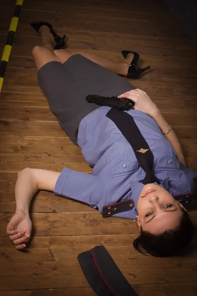 Woman police officer lying on a floor — Stock Photo, Image