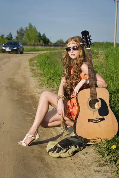 彼女のギターを持つ夏フィールドで若いヒッピーの女の子 — ストック写真