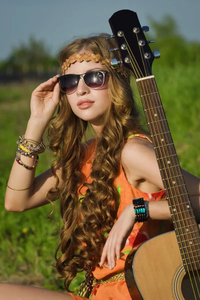 अपने गिटार के साथ एक ग्रीष्मकालीन मैदान पर युवा हिप्पी लड़की — स्टॉक फ़ोटो, इमेज